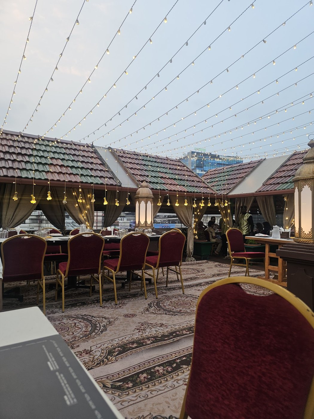 Sagar Restaurant's tiled rooftop terrace at dusk, strung with fairy lights